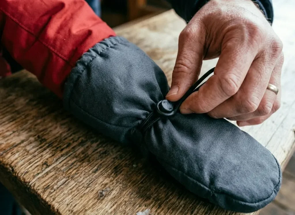 The correct way to seal a toddler ski mitten gauntlet over a winter jacket sleeve to prevent snow entry