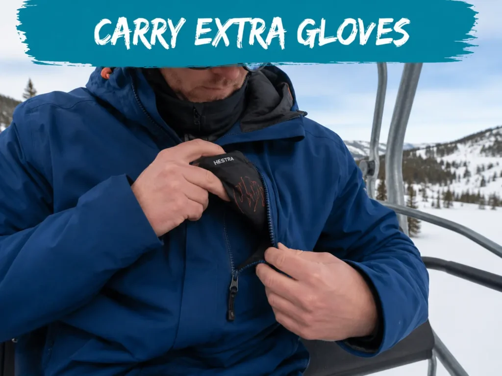 How to carry extra ski gloves — reaching into a jacket chest pocket for a spare pair