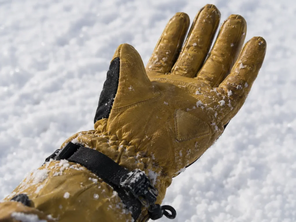 Ski glove gauntlet cuff sealed over a jacket sleeve
