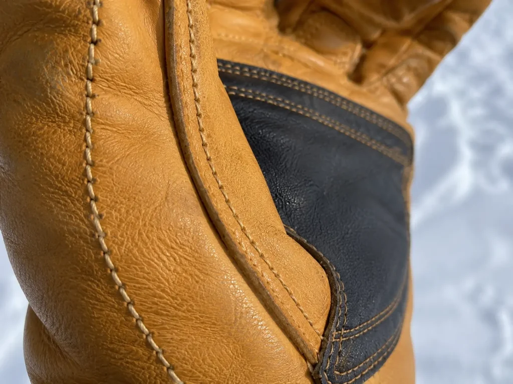 Close-up of double-row stitching on a pro ski glove for maximum durability