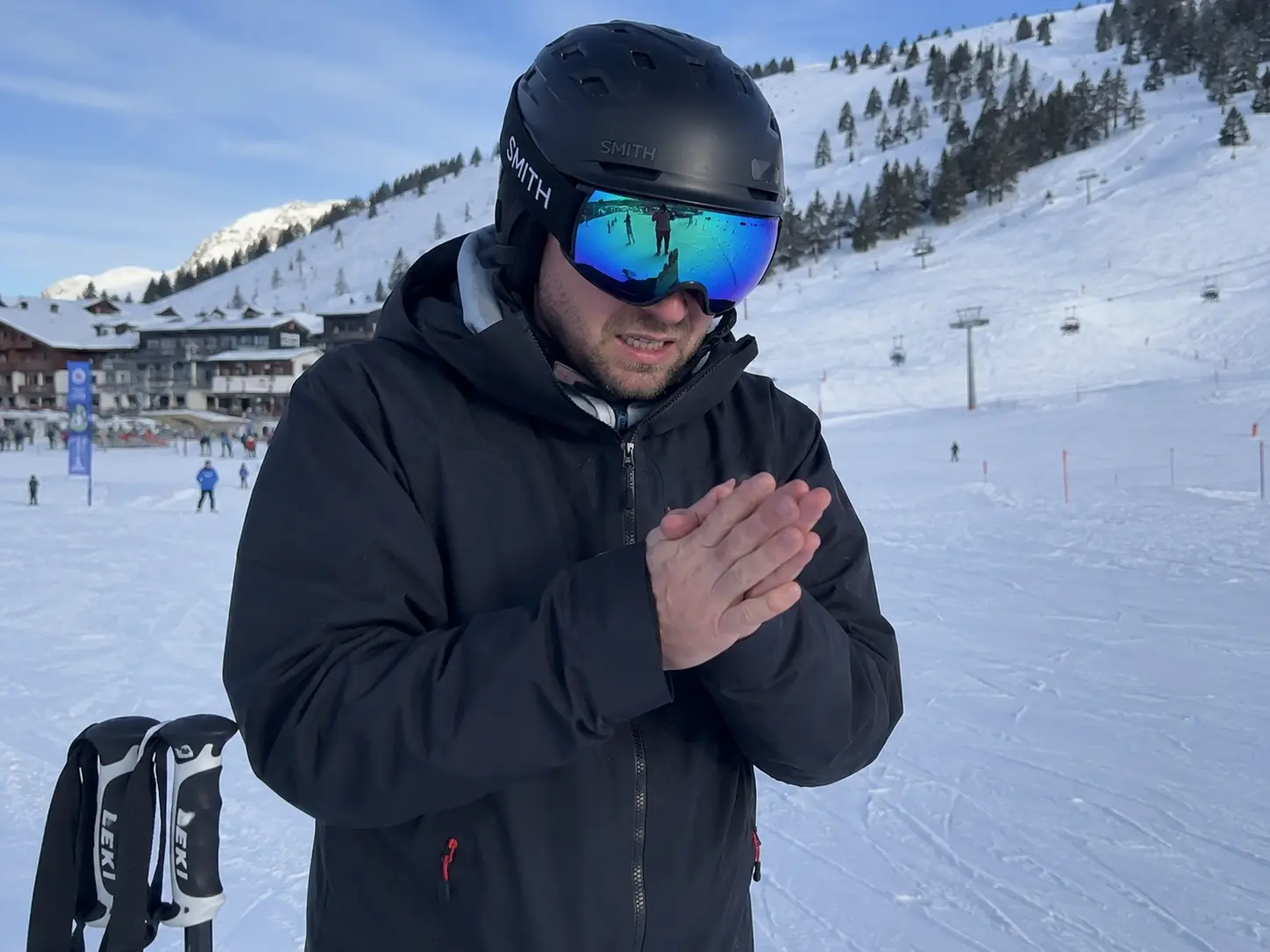 A skier rubbing their hands together, demonstrating the frustration of why are my hands still cold in gloves