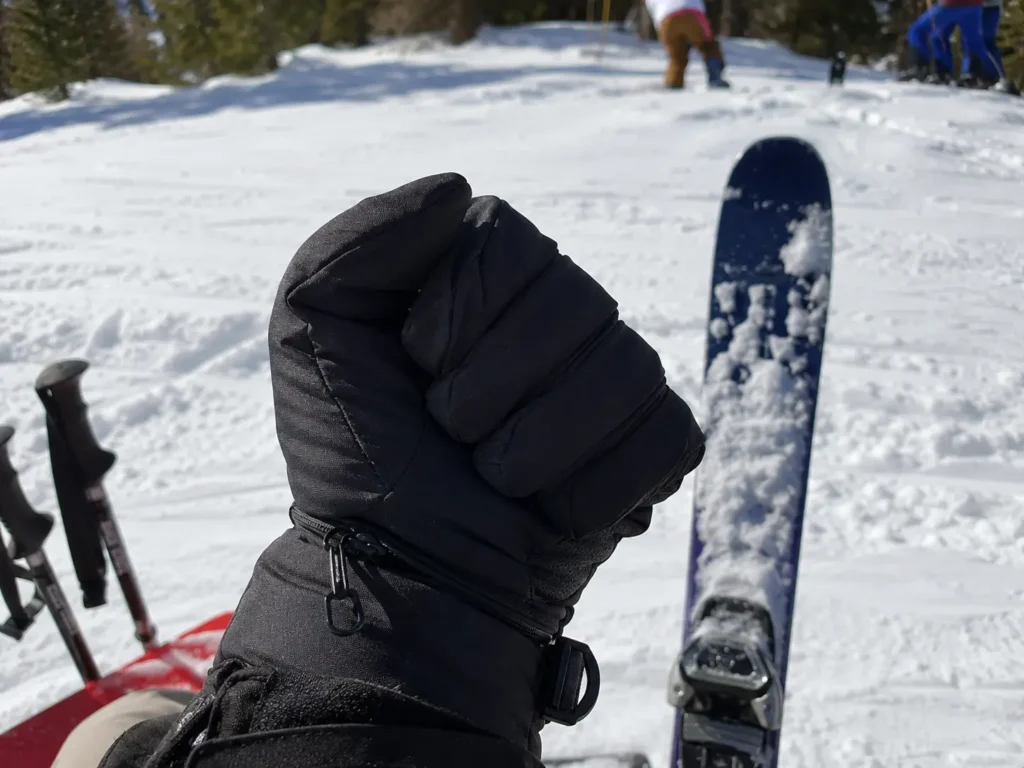 Demonstrating shell fabric stiffness on the mountain to show why do ski gloves feel so bulky