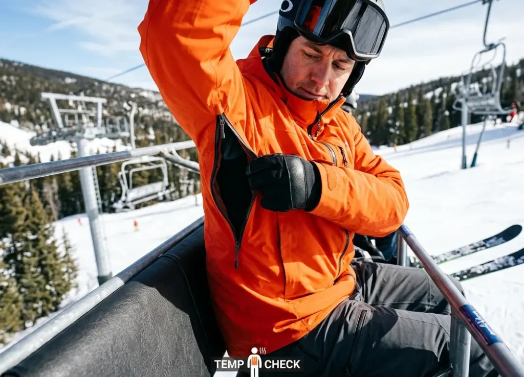 Unzipping jacket pit vents while skiing to lower core temperature and reduce hand sweat