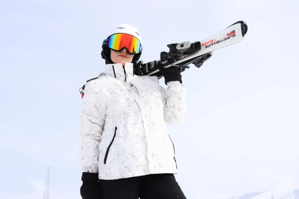 Skier carrying skis on their shoulder in wet snow