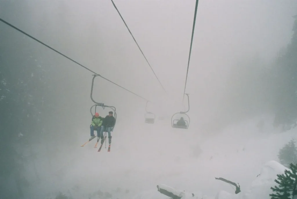 Skier on a chairlift in cold, windy conditions
