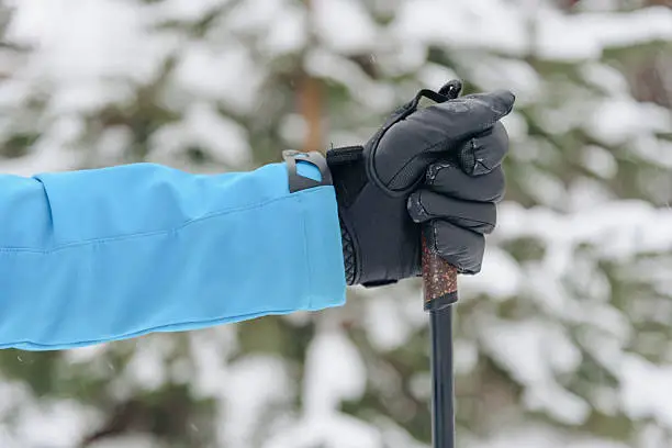 Why gloves lose grip when wet — hand holding a ski pole with visible moisture on the glove palm