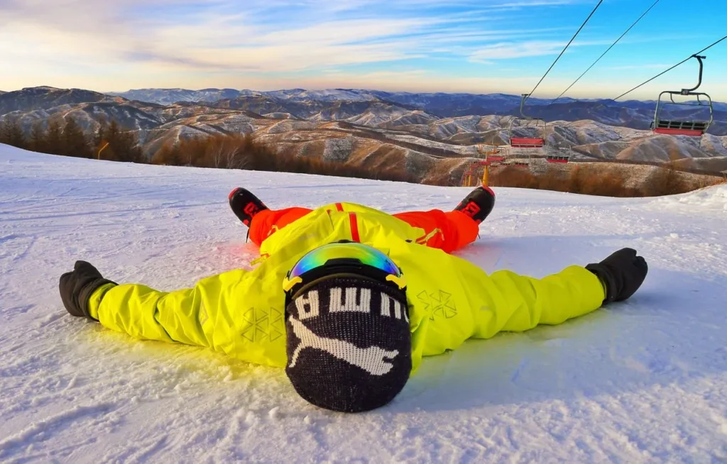 a skier laying on snow extreme cold