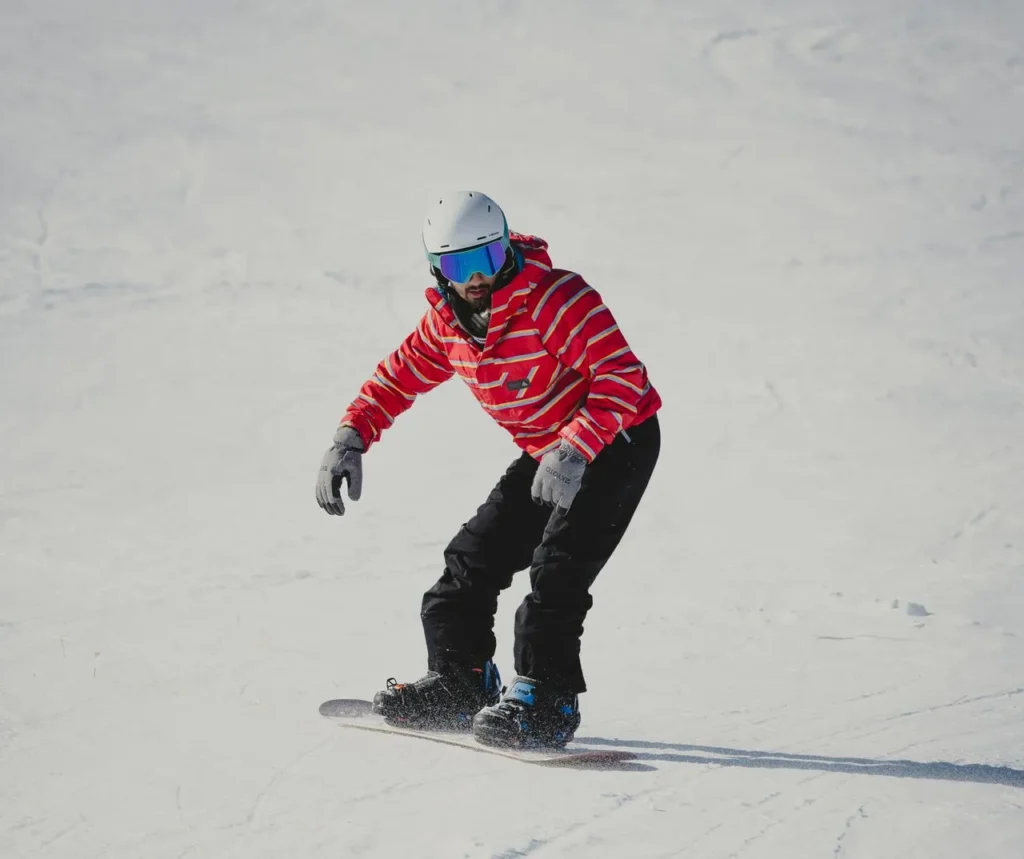Snowboarder adjusting bindings while wearing gloves