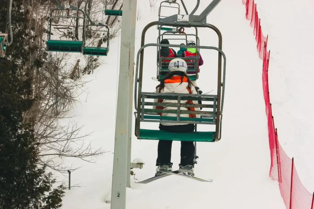 Child on a ski lift wearing winter gloves