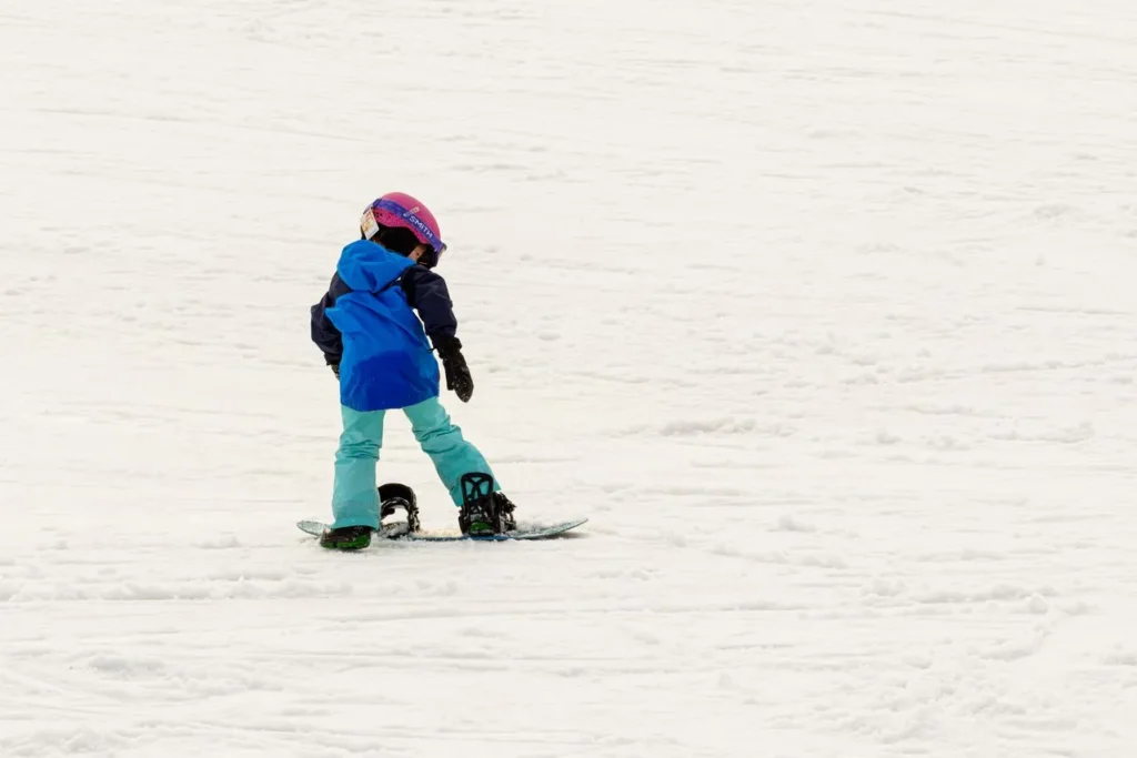 Child skiing wearing waterproof winter gloves