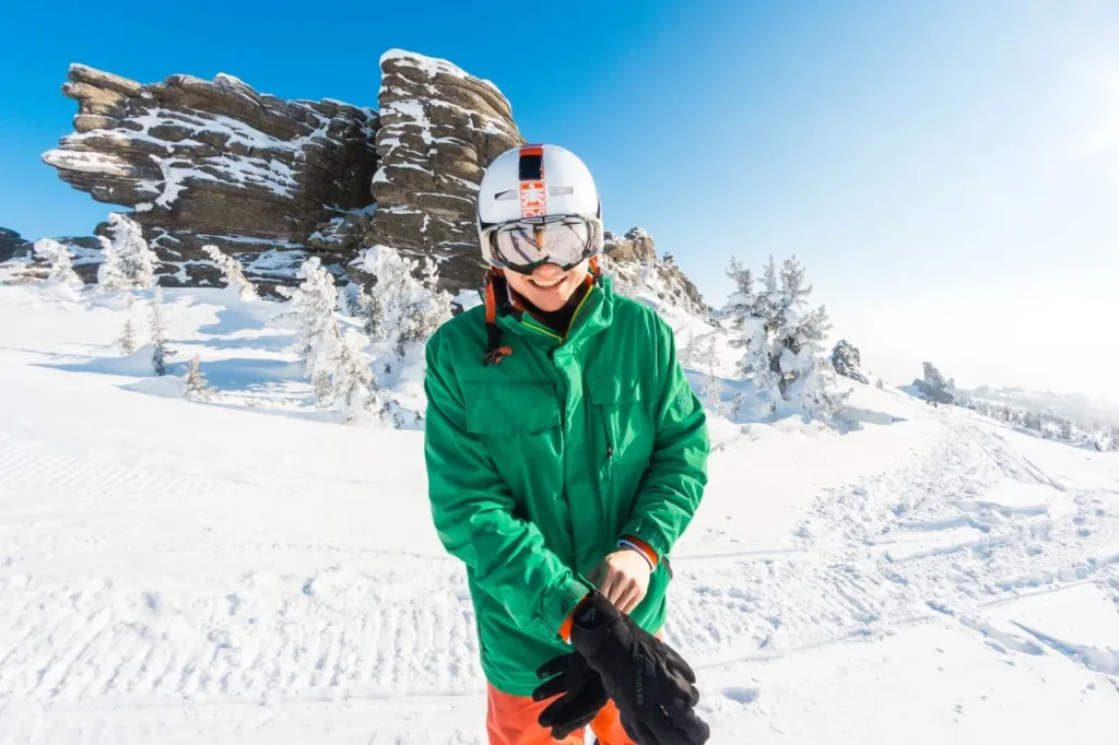Skier putting on gloves before heading up the lift