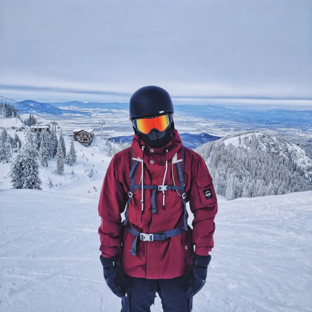 Snowboarder adjusting bindings while wearing gloves
