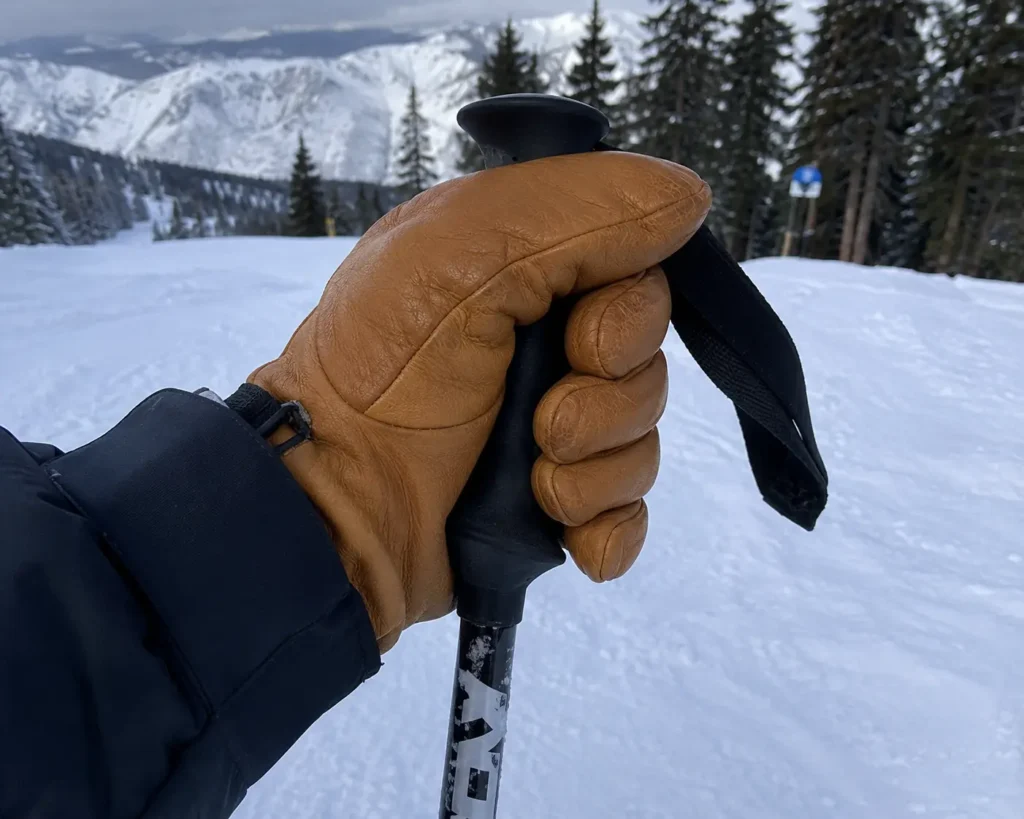 Real leather ski glove gripping a ski pole to demonstrate material flexibility in sub-zero conditions-