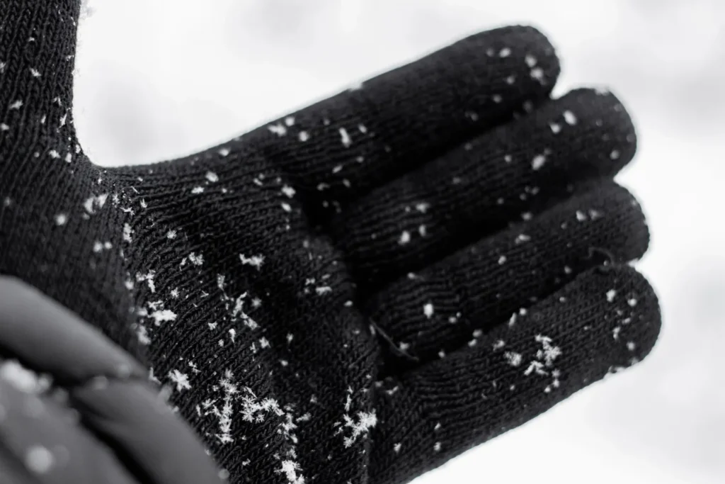 Close-up of waterproof ski glove shell resisting wet snow