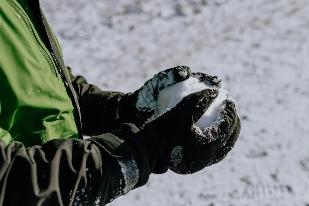 Close-up of ski glove in snow showing waterproof shell texture