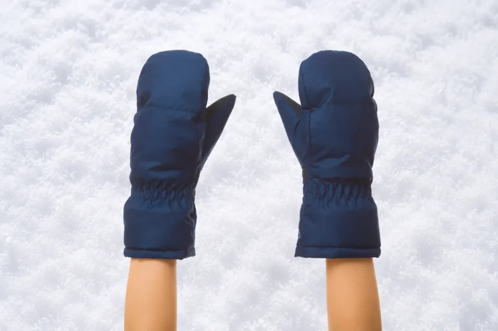 Close-up of insulated ski mitten in snow