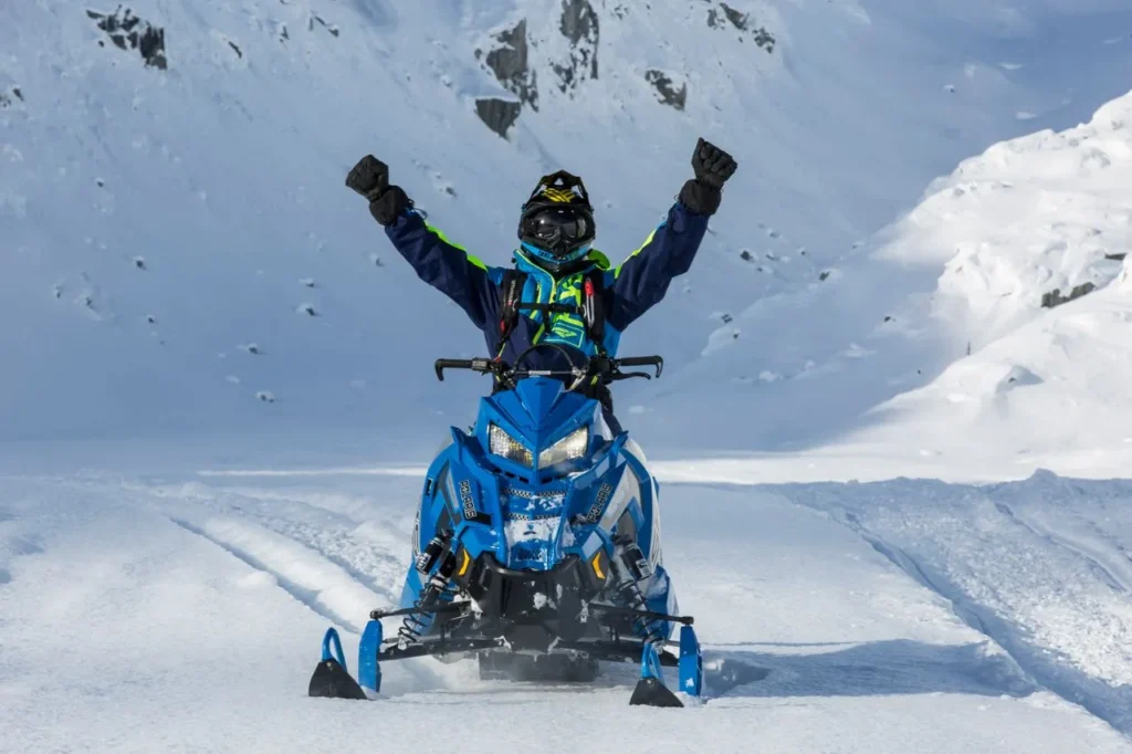 Rider celebrating on a snowmobile — best gloves for snowmobiling